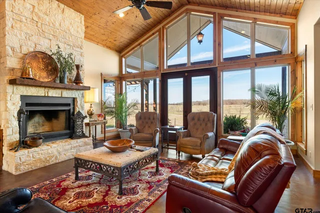 a living room with furniture a fireplace and a floor to ceiling window
