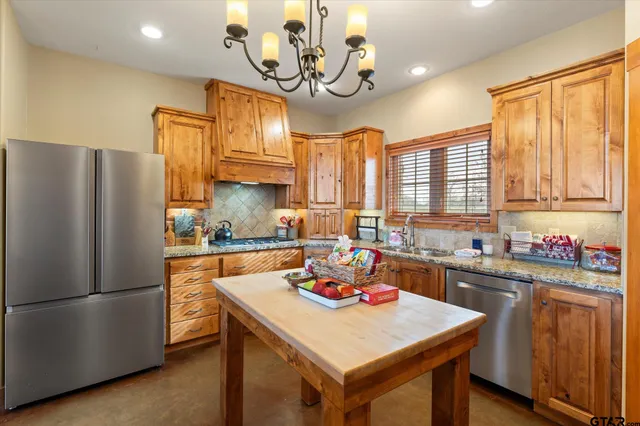 a kitchen with a refrigerator a sink dishwasher stove and oven