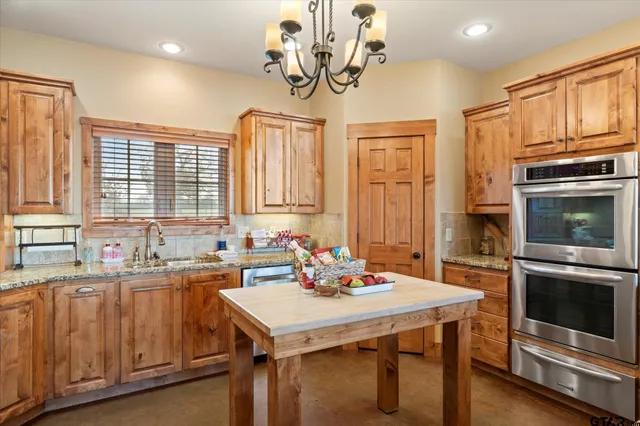 a kitchen with a sink a kitchen island and stainless steel appliances