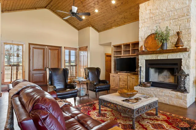a living room with furniture a flat screen tv and a fireplace