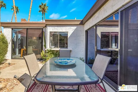 a backyard of a house with table and chairs