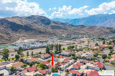 an aerial view of residential houses with outdoor space and parking