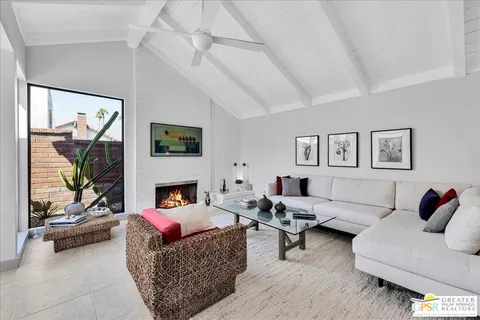 a living room with furniture large window and a fireplace