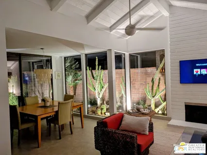 a living room with furniture a fireplace and a chandelier