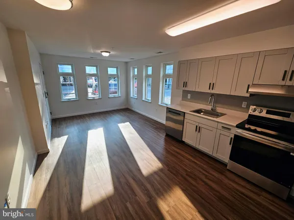 a kitchen with a sink wooden floor and stainless steel appliances