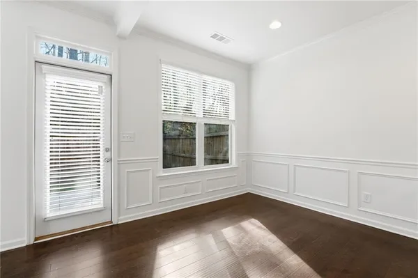 a kitchen with stainless steel appliances granite countertop a stove top oven a sink dishwasher a dining table and chairs with wooden floor