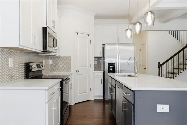 a kitchen with kitchen island a sink stainless steel appliances and cabinets
