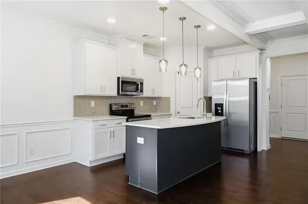 a kitchen with kitchen island a sink stainless steel appliances and cabinets