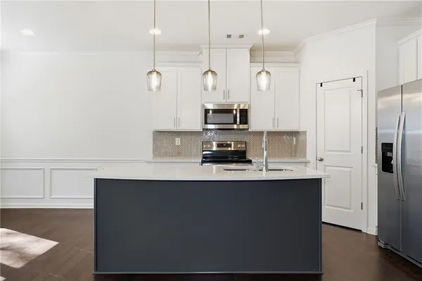 a kitchen with kitchen island white cabinets and black stainless steel appliances