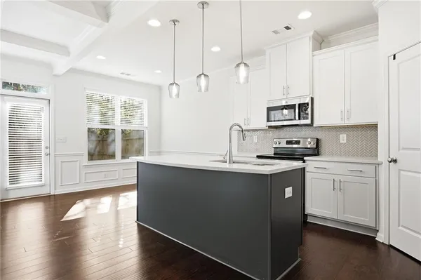 a kitchen with a sink a refrigerator and a chandelier