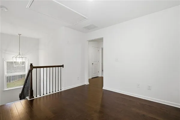an empty room with wooden floor door and windows