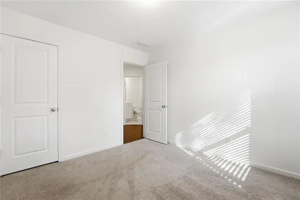 an empty room with closet and a bathroom