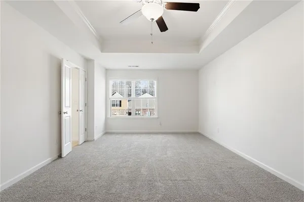 an empty room with windows and ceiling fan