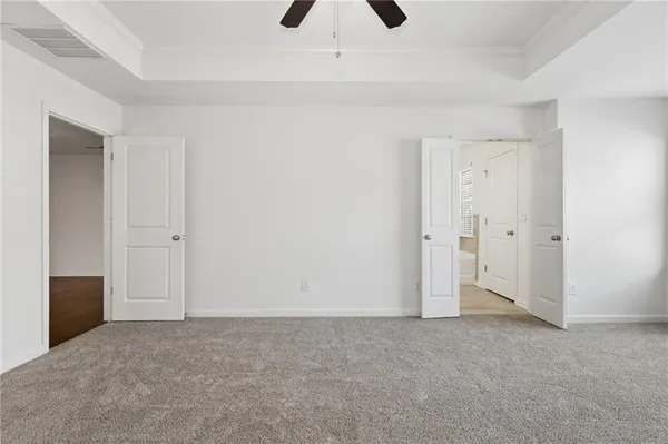 an empty room with ceiling fan and window