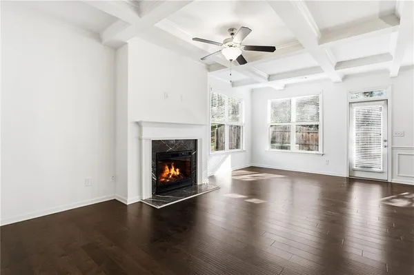 an empty room with wooden floor fireplace and windows
