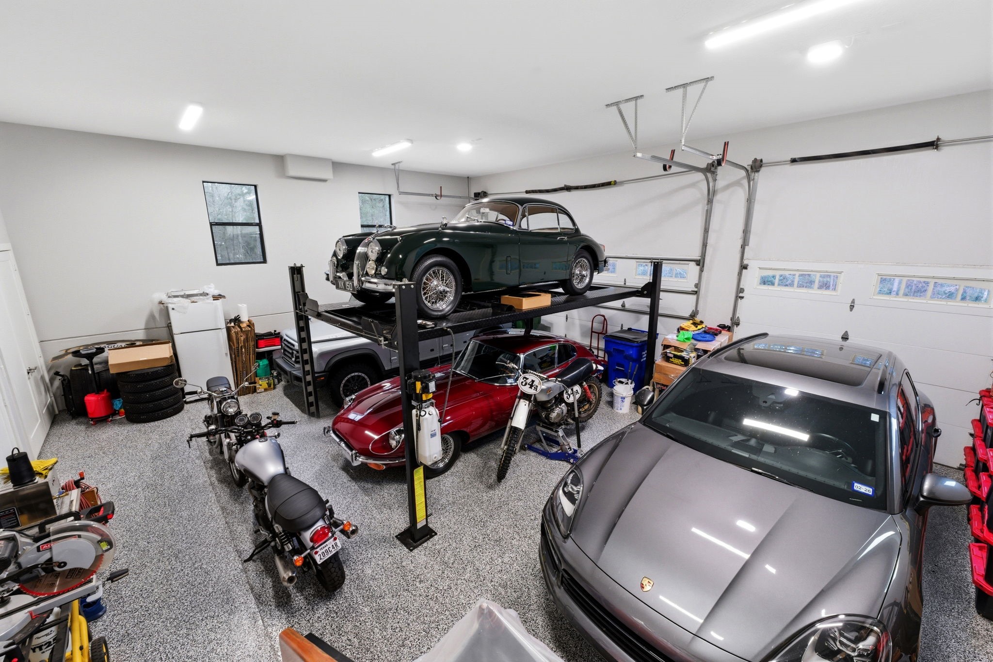 280 Sundog Road Huntsville, TX 77340 - Photo 47 of 50 Oversized three-car garage featuring tall ceilings and epoxy flooring provides ample space for vehicles, projects, and storage, with a vehicle lift that can remain or be removed depending on buyer preference.