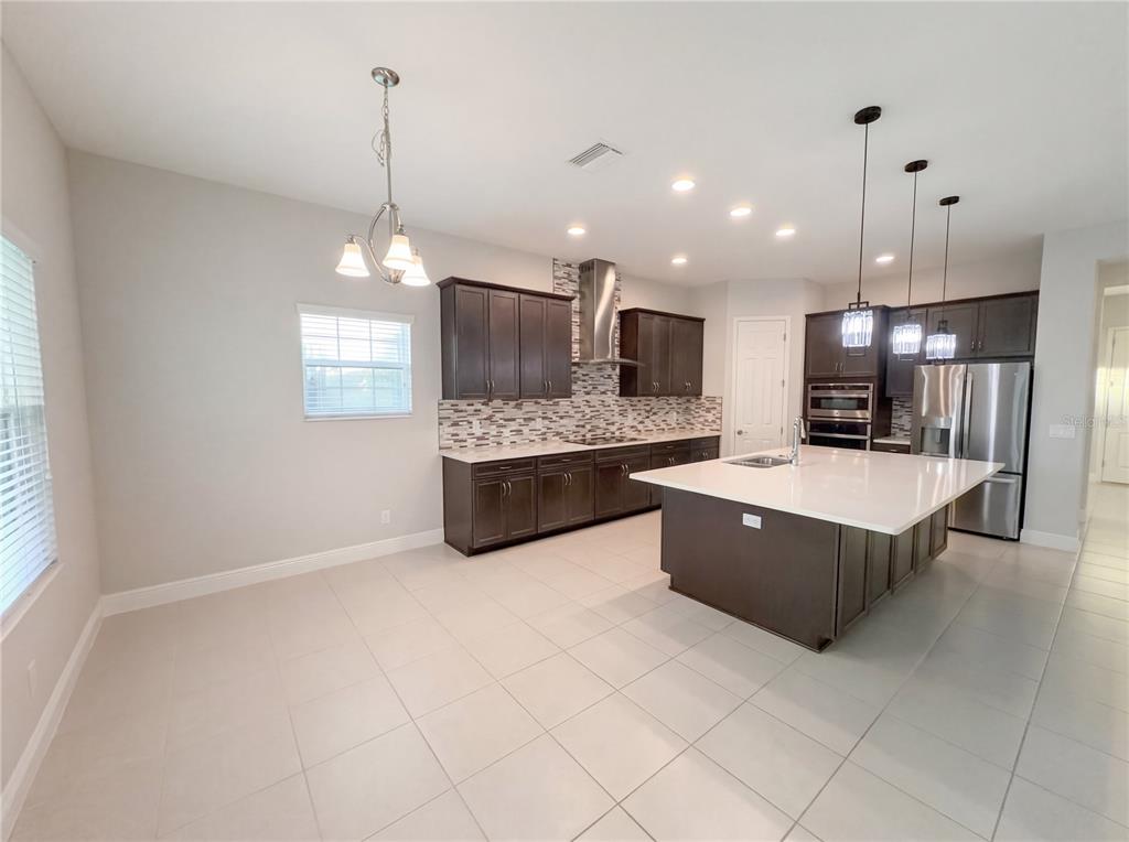 11277 Rustic Timber Loop San Antonio, FL 33576 - Photo 13 of 55 a large kitchen with kitchen island a large counter space a sink a window and stainless steel appliances