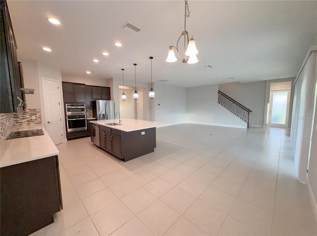 11277 Rustic Timber Loop San Antonio, FL 33576 - Photo 14 of 55 a large kitchen with kitchen island a sink stainless steel appliances and a chandelier