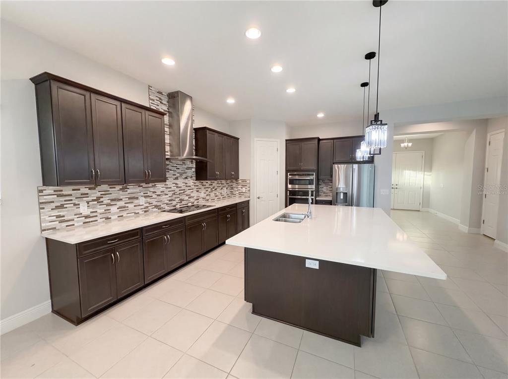 11277 Rustic Timber Loop San Antonio, FL 33576 - Photo 2 of 55 a large kitchen with kitchen island a sink stainless steel appliances and cabinets
