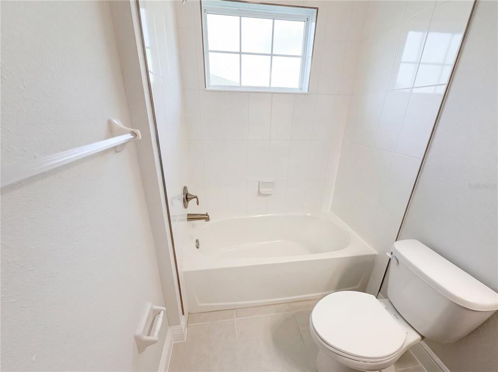 11277 Rustic Timber Loop San Antonio, FL 33576 - Photo 26 of 55 a white toilet and tub sitting next to a window