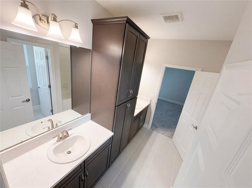 11277 Rustic Timber Loop San Antonio, FL 33576 - Photo 28 of 55 a bathroom with a double vanity sink and mirror