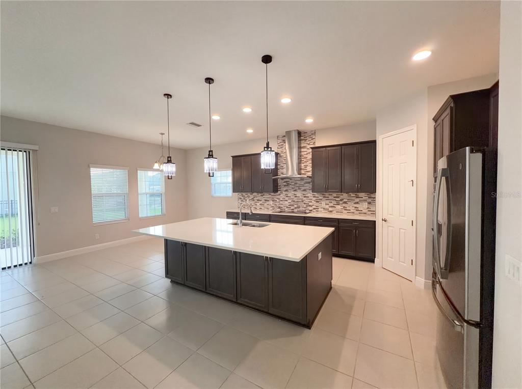 11277 Rustic Timber Loop San Antonio, FL 33576 - Photo 10 of 55 a large kitchen with a large counter top a refrigerator and cabinets