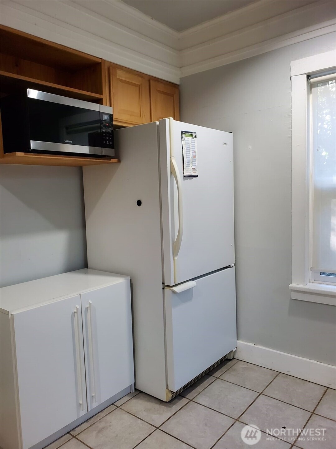 2424 South Graham Street Seattle, WA 98108 - Photo 11 of 23 a white refrigerator freezer and a stove sitting inside of a kitchen