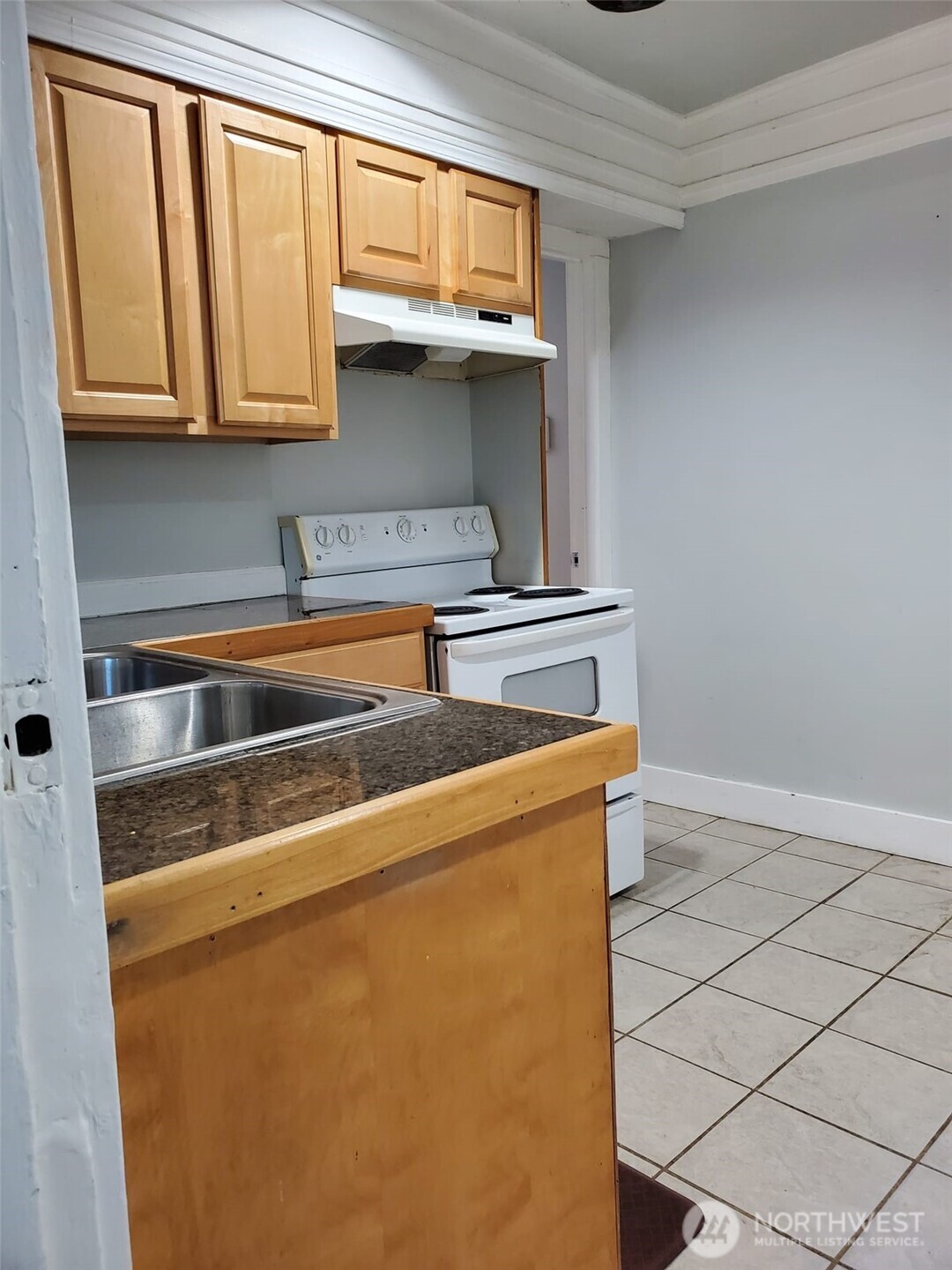 2424 South Graham Street Seattle, WA 98108 - Photo 10 of 23 a kitchen with stainless steel appliances granite countertop a sink a stove and a microwave