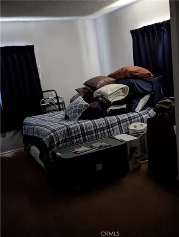 a bed sitting in a bedroom next to a wooden cabinet