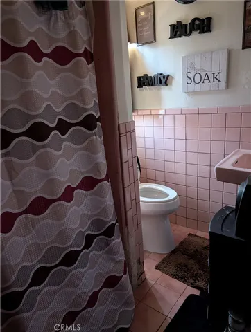a bathroom with a toilet and a shower curtain