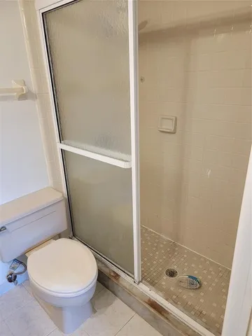 a bathroom with a toilet and a shower