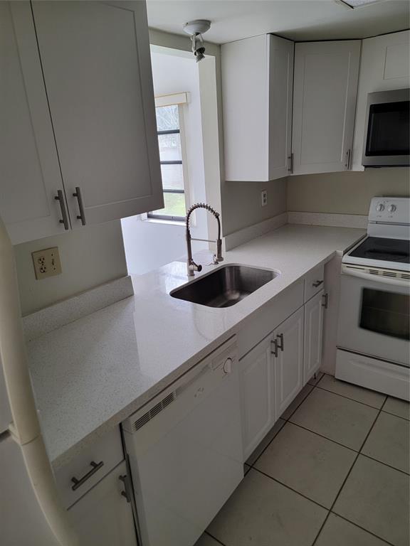 1800 Northeast 39th Court, Unit 1001 Pompano Beach, FL 33064 - Photo 17 of 39 a kitchen with a sink and cabinets