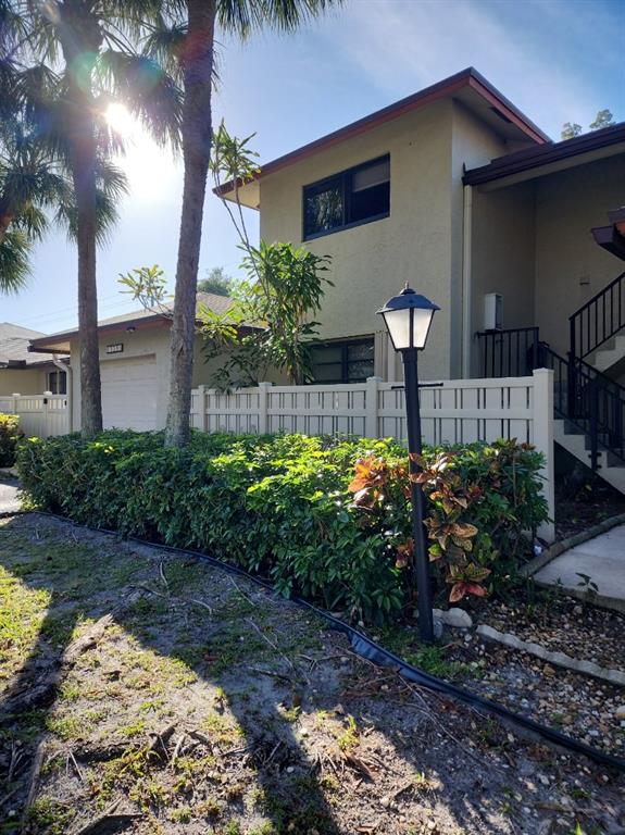 1800 Northeast 39th Court, Unit 1001 Pompano Beach, FL 33064 - Photo 2 of 39 a front view of a house with a yard