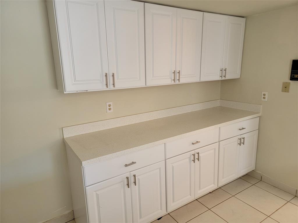 1800 Northeast 39th Court, Unit 1001 Pompano Beach, FL 33064 - Photo 21 of 39 a kitchen with white cabinets