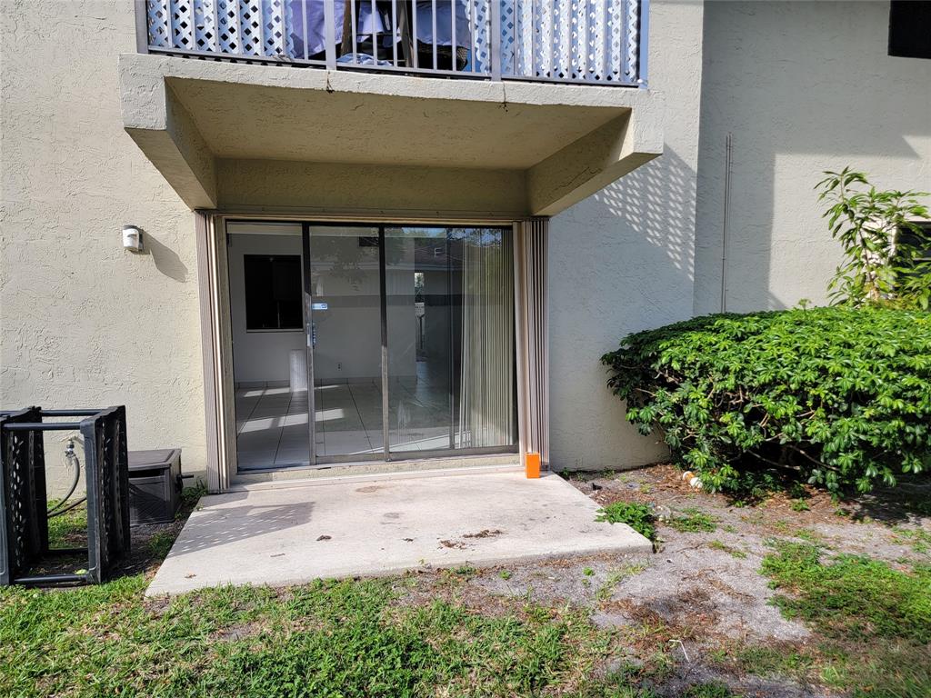 1800 Northeast 39th Court, Unit 1001 Pompano Beach, FL 33064 - Photo 22 of 39 a front view of a house with a yard