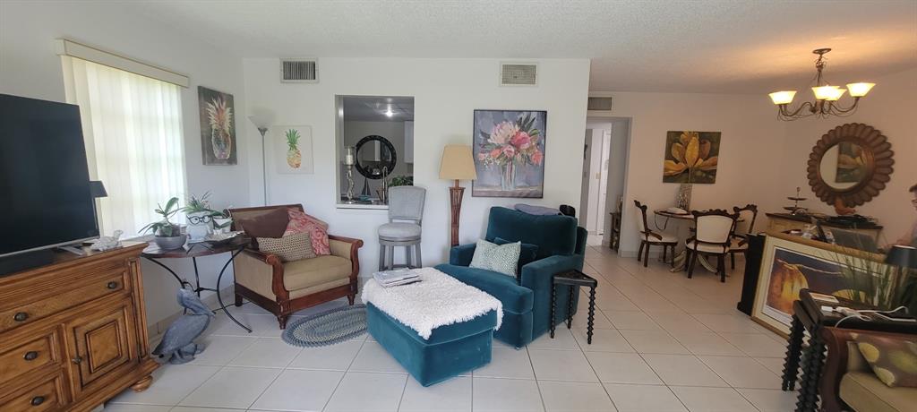 1800 Northeast 39th Court, Unit 1001 Pompano Beach, FL 33064 - Photo 24 of 39 a living room with furniture a flat screen tv and a window