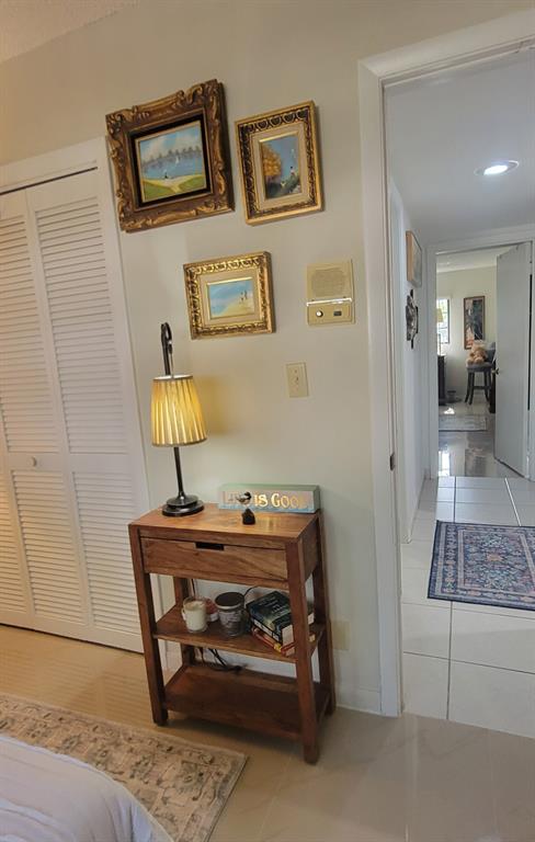 1800 Northeast 39th Court, Unit 1001 Pompano Beach, FL 33064 - Photo 29 of 39 a bedroom with a bed and a lamp on table