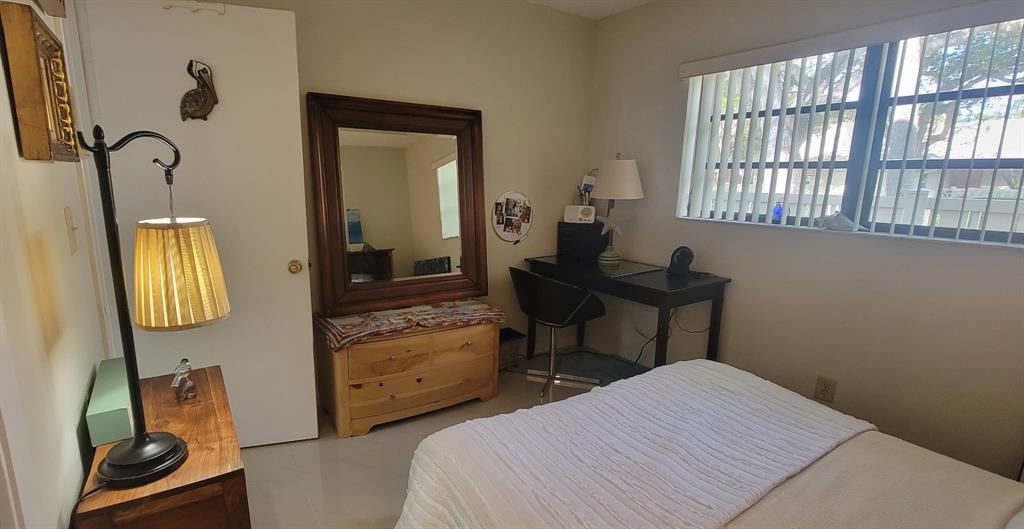 1800 Northeast 39th Court, Unit 1001 Pompano Beach, FL 33064 - Photo 32 of 39 a bedroom with a bed and a mirror on the dresser