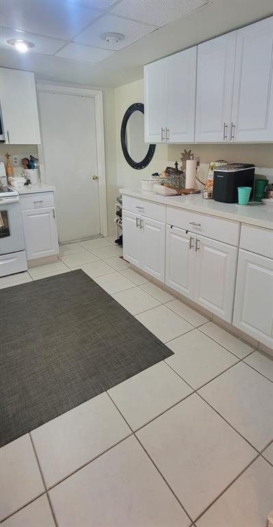 1800 Northeast 39th Court, Unit 1001 Pompano Beach, FL 33064 - Photo 35 of 39 a kitchen with granite countertop a sink a stove and cabinets