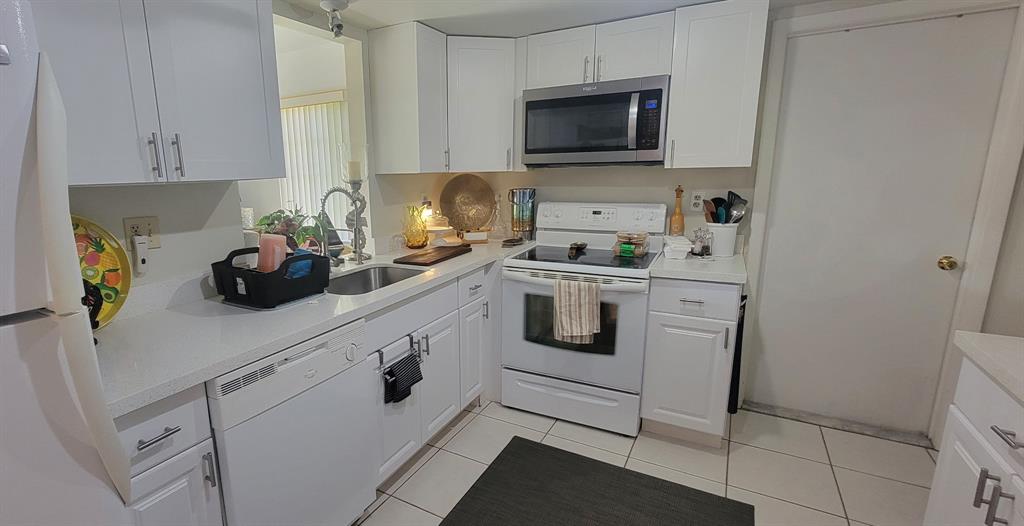 1800 Northeast 39th Court, Unit 1001 Pompano Beach, FL 33064 - Photo 36 of 39 a kitchen with a sink and cabinets