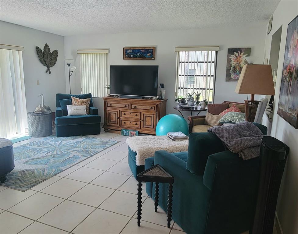 1800 Northeast 39th Court, Unit 1001 Pompano Beach, FL 33064 - Photo 39 of 39 a living room with furniture and a flat screen tv