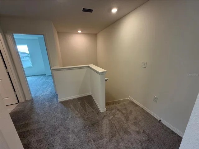 an empty room with wooden floor and entrance