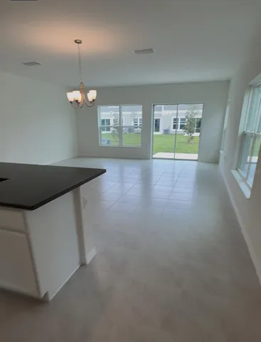 an empty room with windows and chandelier