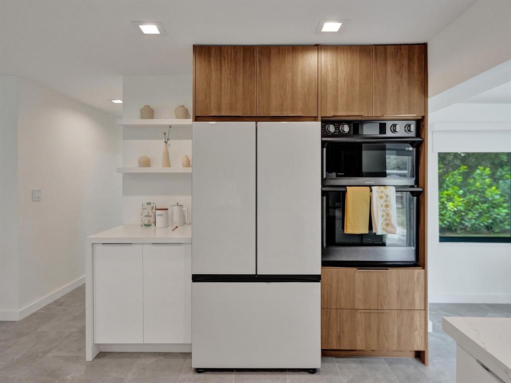 260 Northwest 36th Street Boca Raton, FL 33431 - Photo 28 of 35 a kitchen with kitchen island a counter top space cabinets and stainless steel appliances