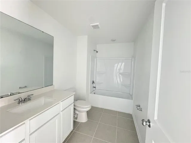 a bathroom with a bathtub sink mirror toilet and