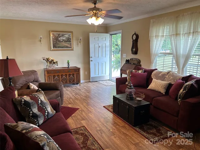 a living room with furniture a large window and a chandelier