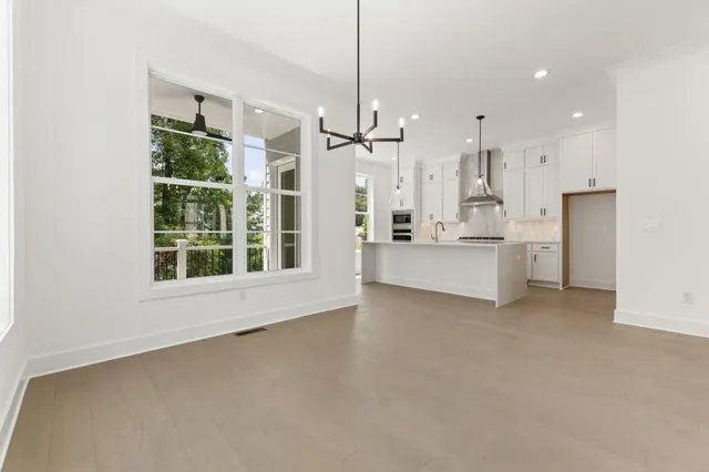 a kitchen with stainless steel appliances a stove a sink and white cabinets