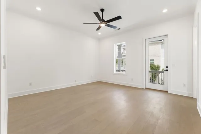 an empty room with wooden floor and windows