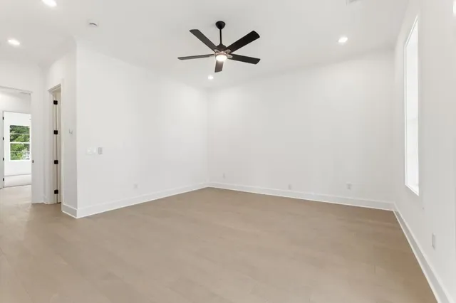 a view of a small space with wooden floor and a ceiling fan