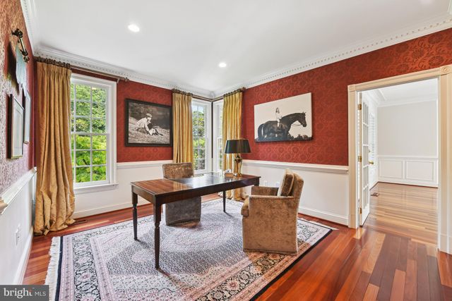 a living room with furniture a wooden floor and a large window